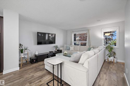 Spacious living area featuring light wood-finish flooring, white baseboards, and light gray walls - 12305 173A Avenue Nw, Edmonton, AB - Indoor Photo Showing Living Room
