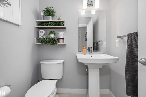 Pedestal sink with a rectangular basin, chrome faucet, and mirrored vanity - 12305 173A Avenue Nw, Edmonton, AB - Indoor Photo Showing Bathroom