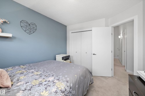 Carpeted room with a blue accent wall and white trim - 12305 173A Avenue Nw, Edmonton, AB - Indoor Photo Showing Bedroom