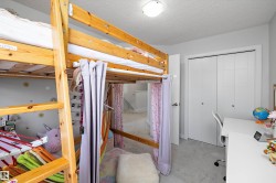 Carpeted bedroom featuring light-toned walls and a built-in closet with bi-fold doors - 