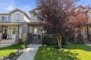 Contemporary facade featuring light grey siding, a covered front porch, and a mature tree with vibrant foliage - 12305 173A Avenue Nw, Edmonton, AB  - Outdoor With Facade 