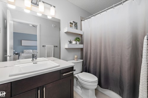Bathroom featuring a dark wood-finish vanity with a white countertop and integrated rectangular sink - 12305 173A Avenue Nw, Edmonton, AB - Indoor Photo Showing Bathroom