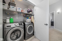 Dedicated laundry area featuring front-loading appliances, overhead wire shelving, and neutral wall paint - 