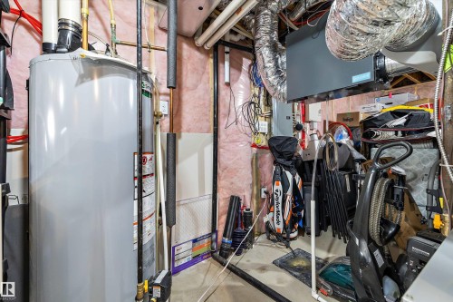 Dedicated utility space featuring a water heater, visible piping, and exposed ductwork - 12305 173A Avenue Nw, Edmonton, AB - Indoor Photo Showing Basement