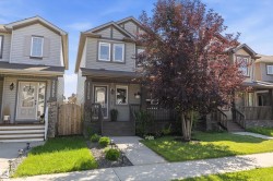 Gray siding exterior with dark trim accents and stone detailing - 