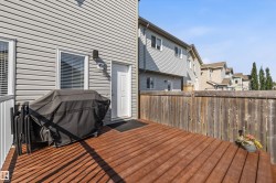 Spacious outdoor deck with rich wood-finish flooring, surrounded by a privacy fence - 