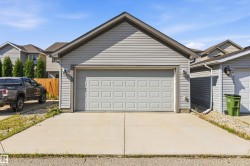 Detached garage with light gray siding and a paneled overhead door - 