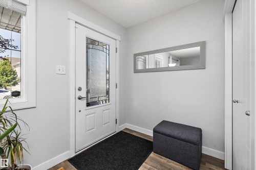 Entryway featuring a decorative glass panel door, durable wood-finish flooring, and a sidelight window - 12305 173A Avenue Nw, Edmonton, AB - Indoor
