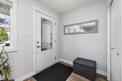 Entryway featuring a decorative glass panel door, durable wood-finish flooring, and a sidelight window - 
