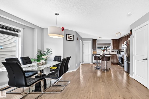 Open-concept main level featuring light wood-finish flooring throughout - 5280 21 Avenue Sw, Edmonton, AB - Indoor Photo Showing Dining Room