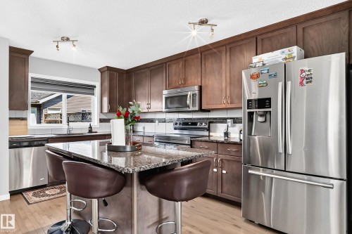 Kitchen featuring wood-finish cabinetry, granite countertops, and stainless steel appliances - 5280 21 Avenue Sw, Edmonton, AB - Indoor Photo Showing Kitchen With Stainless Steel Kitchen