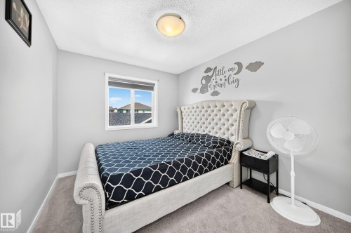 Light gray painted walls with a textured ceiling and flush mount lighting - 5280 21 Avenue Sw, Edmonton, AB - Indoor Photo Showing Bedroom