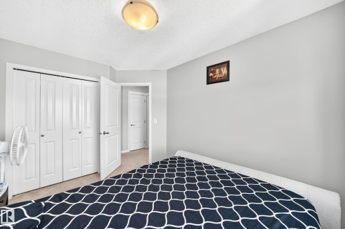 Light gray walls with a textured ceiling and a flush-mount light fixture - 5280 21 Avenue Sw, Edmonton, AB - Indoor Photo Showing Bedroom