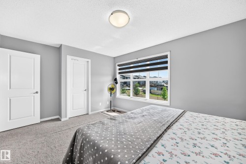 Carpeted room with a large window featuring horizontal blinds - 5280 21 Avenue Sw, Edmonton, AB - Indoor Photo Showing Bedroom