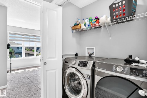 Dedicated laundry area featuring wire shelving, light grey wall paint, and a visible washer/dryer hookup - 5280 21 Avenue Sw, Edmonton, AB - Indoor Photo Showing Laundry Room