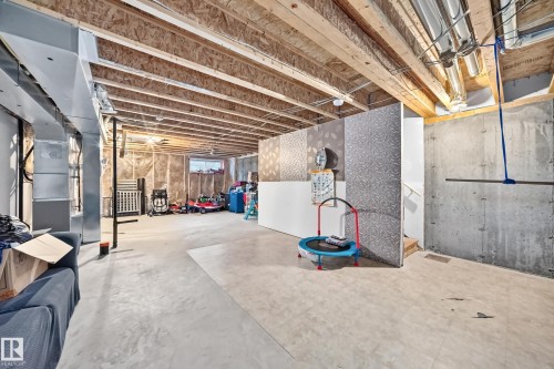 Unfinished basement with exposed wood joists and concrete flooring - 5280 21 Avenue Sw, Edmonton, AB - Indoor Photo Showing Basement