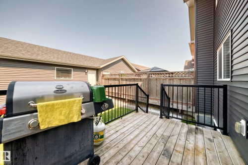 Spacious wooden deck with black metal railings, offering outdoor living space - 5280 21 Avenue Sw, Edmonton, AB - Outdoor With Deck Patio Veranda With Exterior