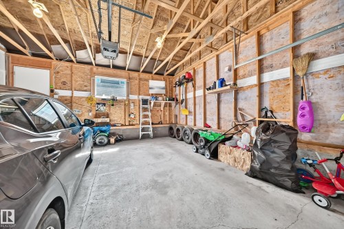 Attached garage featuring exposed wood framing and a concrete floor - 5280 21 Avenue Sw, Edmonton, AB - Indoor Photo Showing Garage