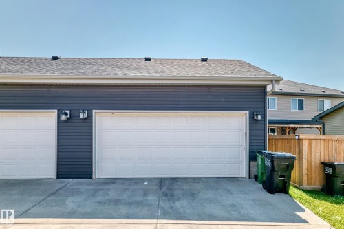 Two-car garage featuring white panel doors, charcoal horizontal siding, and a concrete driveway - 5280 21 Avenue Sw, Edmonton, AB - Outdoor With Exterior