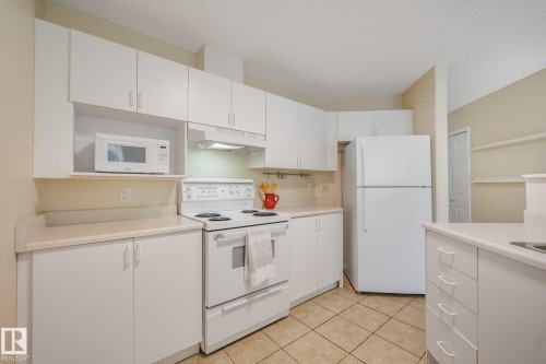 Room with light-toned walls, laminate flooring, and a large window - #206, 9905 112 St Nw, Edmonton, AB - Indoor Photo Showing Bedroom