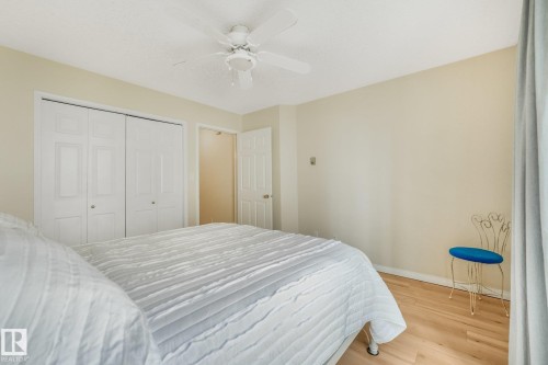 2nd Bedroom (or Office) featuring light laminate flooring, neutral wall tones, and a large multi-pane window with white trim - #206, 9905 112 St Nw, Edmonton, AB - Indoor Photo Showing Other Room