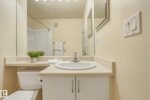 Dedicated IN SUITE laundry area featuring stacked washer and dryer plus storage. - #206, 9905 112 St Nw, Edmonton, AB - Indoor Photo Showing Laundry Room