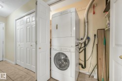 Dedicated IN SUITE laundry area featuring stacked washer and dryer plus storage. - 