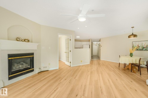 Light-toned laminate flooring extending throughout the open area - #206, 9905 112 St Nw, Edmonton, AB - Indoor