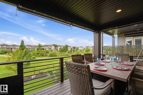 Covered deck featuring wood-finish flooring and a black horizontal bar railing - 3 Garneau Gate, Spruce Grove, AB - Outdoor With Deck Patio Veranda With Exterior