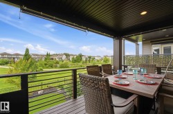 Covered deck featuring wood-finish flooring and a black horizontal bar railing - 