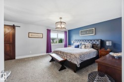 Spacious room featuring gray carpeting, a window with exterior views, and a contemporary chandelier - 