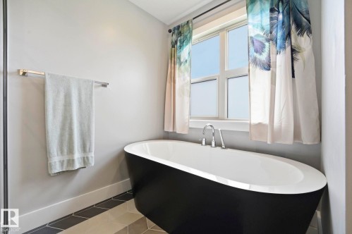 Freestanding black and white soaking tub with polished chrome fixtures - 3 Garneau Gate, Spruce Grove, AB - Indoor Photo Showing Bathroom