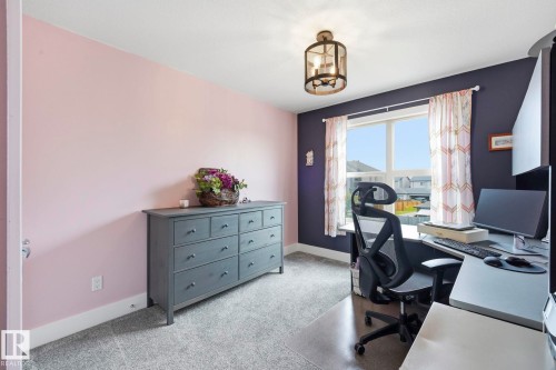 Carpeted room featuring a large window, a built-in light fixture, and two-tone wall finishes - 3 Garneau Gate, Spruce Grove, AB - Indoor Photo Showing Office