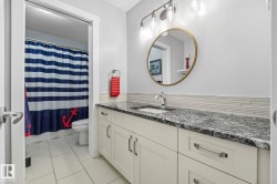Bathroom vanity featuring a dark patterned countertop, an undermount sink, and brushed nickel fixtures - 