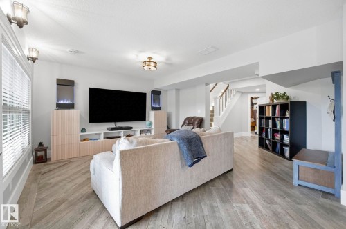 Spacious living area featuring wood-look flooring, recessed lighting, and built-in cabinetry - 3 Garneau Gate, Spruce Grove, AB - Indoor Photo Showing Living Room