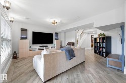Spacious living area featuring wood-look flooring, recessed lighting, and built-in cabinetry - 