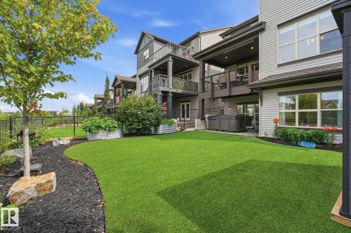 Backyard featuring a synthetic lawn, black rock landscaping, and a fenced perimeter - 3 Garneau Gate, Spruce Grove, AB - Outdoor