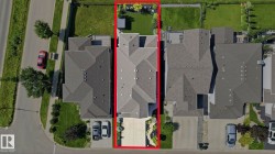 Expansive property featuring a multi-gabled roofline, a large paved driveway, and a generously sized backyard with a manicured lawn and mature trees - 