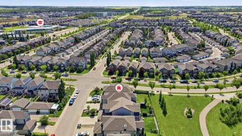 Expansive aerial depiction of a residential neighborhood featuring numerous detached and attached housing units, curvilinear street patterns, and abundant green spaces - 3 Garneau Gate, Spruce Grove, AB - Outdoor With View