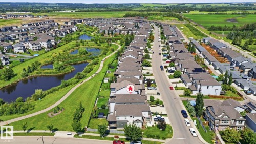 Aerial perspective showcasing a residential community with a paved road and homes featuring dark roofs - 3 Garneau Gate, Spruce Grove, AB - Outdoor With View