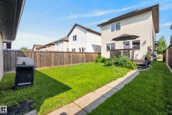 Expansive backyard featuring a manicured lawn, full wood-plank fencing, and a concrete pathway - 