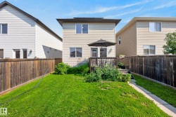 Rear exterior featuring a raised wood deck, privacy fencing, and a grassy yard - 
