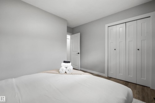 Bedroom featuring light grey walls, wood-finish flooring, and white bi-fold closet doors - 4001 113 Avenue Nw, Edmonton, AB - Indoor Photo Showing Bedroom