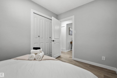 Room featuring light gray walls, wood-finish flooring, white trim, and a bi-fold closet with panel doors - 4001 113 Avenue Nw, Edmonton, AB - Indoor Photo Showing Bedroom