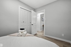 Room featuring light gray walls, wood-finish flooring, white trim, and a bi-fold closet with panel doors - 