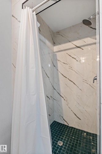 Shower enclosure featuring white marble-look wall tiles with dark veining and a green square tile floor - 4001 113 Avenue Nw, Edmonton, AB - Indoor Photo Showing Bathroom