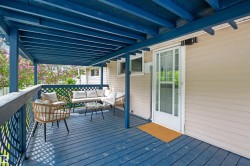 Covered porch with blue-stained decking and lattice railing - 