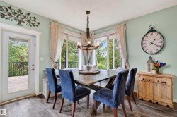 Dining area featuring wood-finish flooring, a full-lite exterior door, and large windows - 