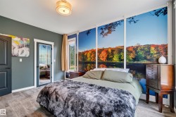 Bedroom featuring an expansive wall mural, wood-finish flooring, a contemporary ceiling light fixture, a paneled interior door, and a glass-paneled interior door with white trim - 