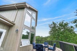 Multi-level deck featuring wood-finish flooring and black metal railings - 